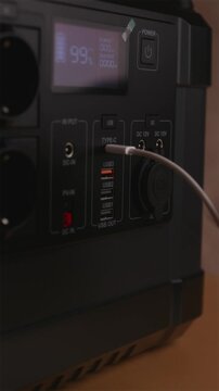 Connecting USB-C cable to portable power station for charging devices at home
