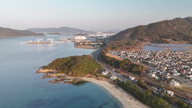 Aerial drone view of cars driving along a coastal road by the blue sea in Japan 02