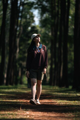 Obraz premium Asian woman relaxing in forest nature wellness mindfulness peaceful outdoor lifestyle mental health wellbeing natural therapy environment calm happiness sitting among trees