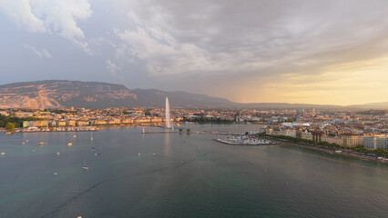 Naklejka premium Golden evening over Geneva. Calm twilight at Geneva with reflections and mountain silhouette