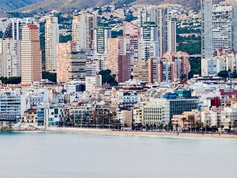 Bustling Shoreline With Mountain Backdrop, Expansive City Horizon Featuring Dense Housing And Ocean Views