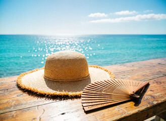 wide-brimmed straw sun hat and a hand fan on the table