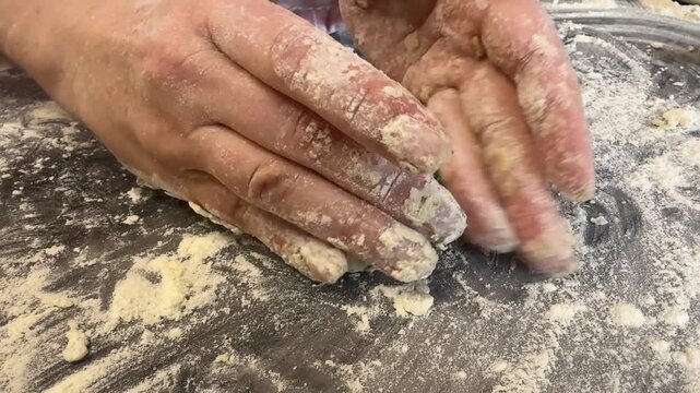 Woman making syrniki: shapes round patties from cottage cheese dough, dredges each piece in flour. Traditional Russian recipe.