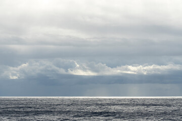 Obraz premium Storm clouds over the Mediterranean Sea at sunset, sailing on a cruise ship towards the strait.