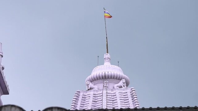 Drone view of temple shikhara with sacred flag waving atop in Odisha, India.