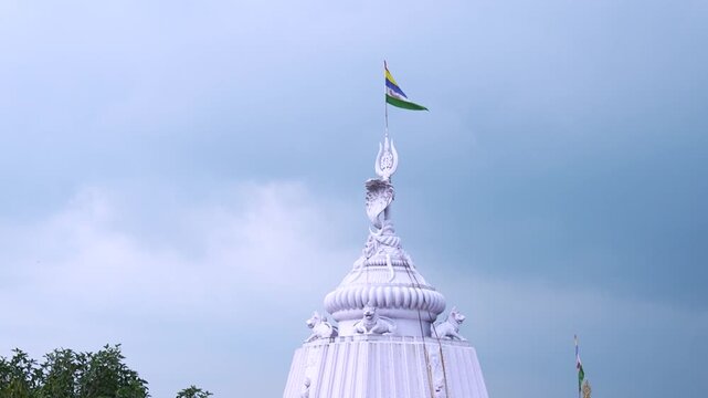 Drone view of temple shikhara with sacred flag waving atop in Odisha, India.