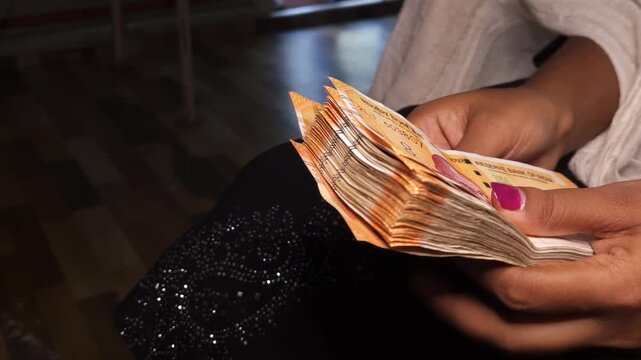 Close up of hands counting Indian 200 rupee notes. Financial transaction concept showing cash handling, savings, economy, income, and money management in India. Ideal for banking and business themes.