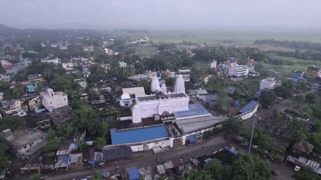 Wide aerial drone shot of Chhatia Bata Jagannath Temple surrounded by greenery in Odisha, India.