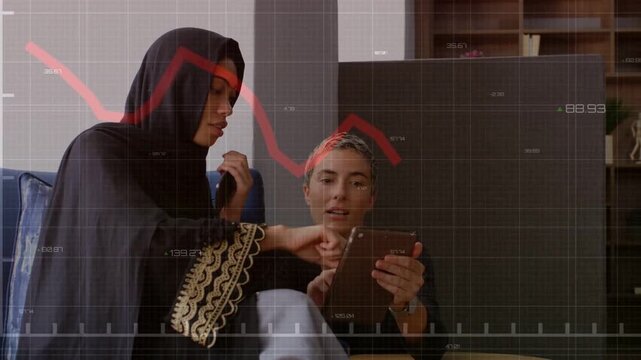 Left woman tapping tablet right woman showing analyzing finance data as red chart overlaying tablet