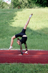A dedicated gymnast performs with skill and focus on a sunny day, showcasing a rhythmic pose...