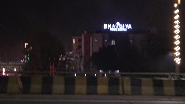 Night traffic on busy urban road with cars, buses and street lights, long queue of vehicles under dark sky, transportation and travel scene showing motion, infrastructure evening city life in India