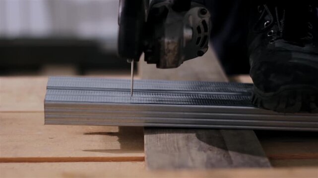 A builder cuts profiles for drywall using a circular saw.