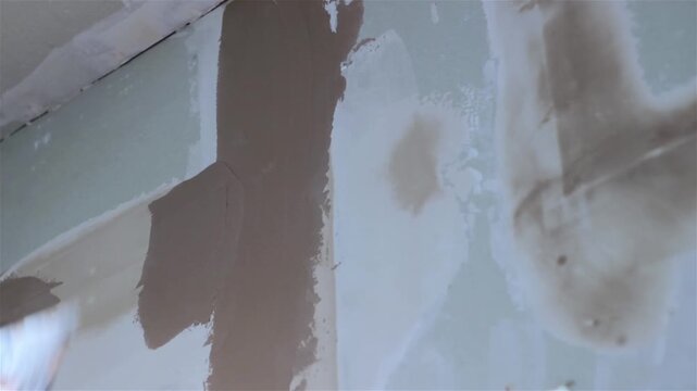 The builder is applying plaster to the new drywall installation., video