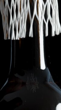 Vertical video. A man's hand removes the white protective netting from the wine bottle. Close-up.
