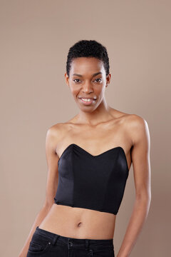 Beautiful confident Black woman with short natural hair posing in studio on beige background