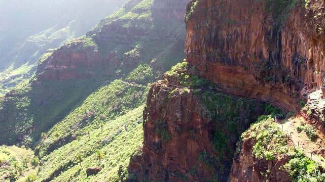 Schwindelerregender Wanderweg an einer riesigen Felswand im Barranco de Guarimiar auf La Gomera