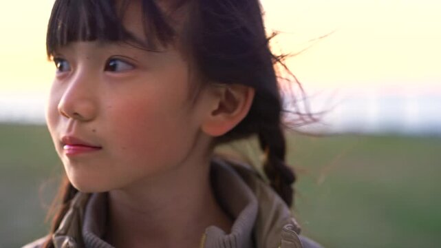 Outdoor, thinking and child with smile for holiday, remember funny memory and positive mindset for trip. Wind, laughing and asian girl with reflection for vacation, sightseeing and view location