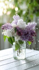 Obraz premium Soft purple lilac bouquet in clear glass jar on wooden table with natural light