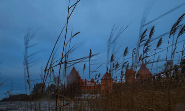 the island castle of trakai, lithuania through the grass