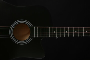 Obraz premium Modern black guitar on dark background, closeup