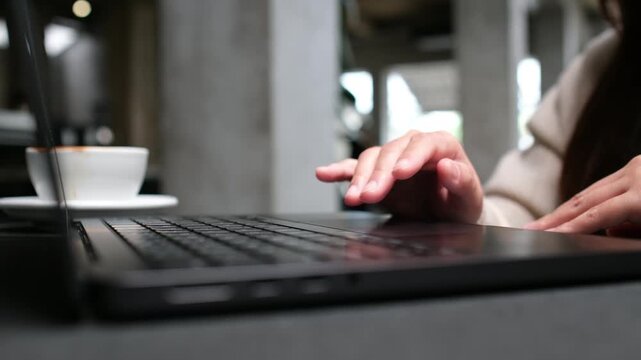 Closeup of a woman working and touching on laptop computer touchpad