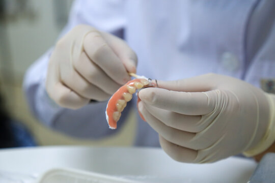 Dental Professional Performing Maintenance on a Removable Partial Denture