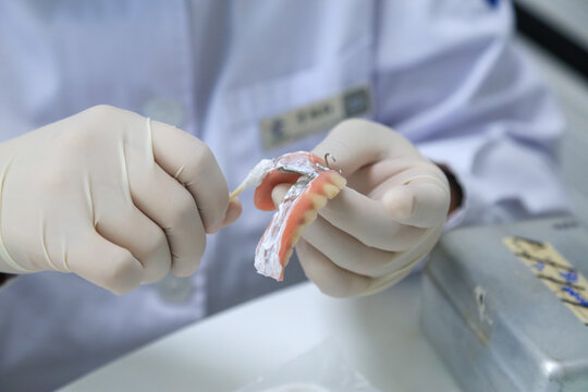 Dental Professional Performing Maintenance on a Removable Partial Denture