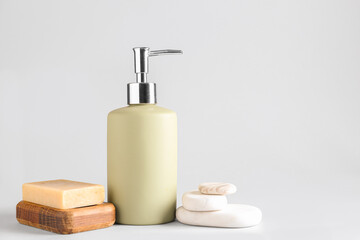 Obraz premium Soap dispenser with stones on white background