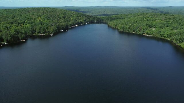 Aerial over Buckskin Lake on a summer afternoon. Lakeside cottages along side expansive crown land wilderness in Tory Hill, Halliburton Highlands East, in southern Ontario, Canada. 
