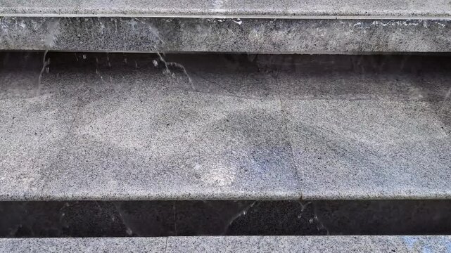 Steps show water flowing after rain in park area during afternoon