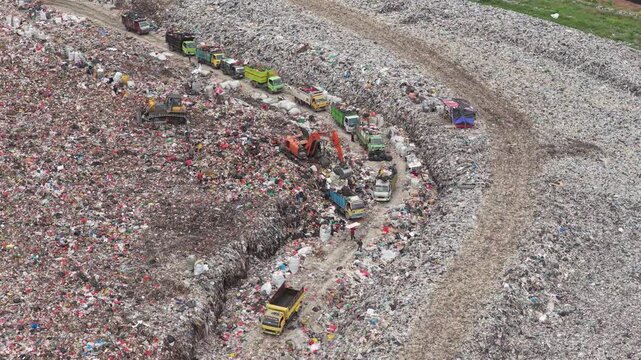 Aerial view of garbage trucks at a landfill environmental pollution site