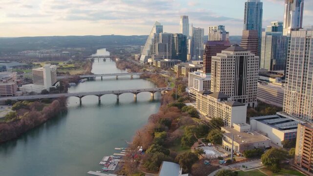 Aerial drone footage flying over Lady Bird Lake showcasing the downtown Austin skyline and city bridges at sunset