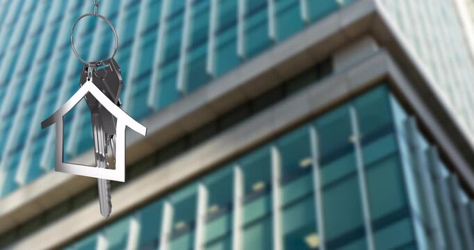 Animation of silver house key and key fob over modern building