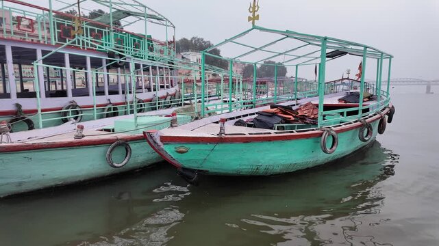 Traditional Passenger Boats Docked on River with Bridge in Background