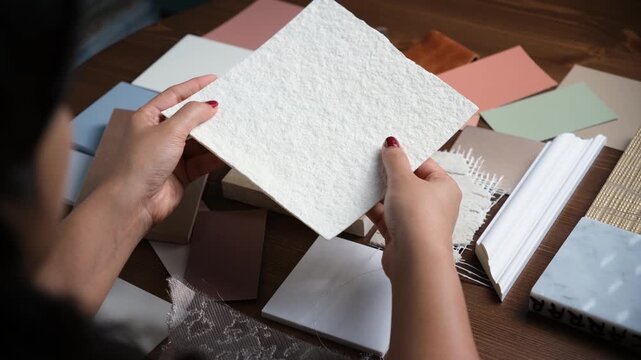 Interior designer selecting white texture material sample for modern interior design
