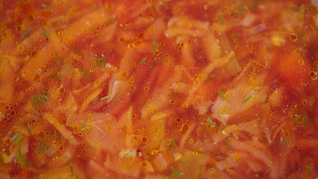 Hearty soup imagery. Close view of simmering beet soup with vegetables and herbs. Detailed depiction of hot borscht with shredded cabbage and tender meat pieces