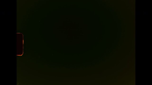 A dark abstract film background with visible scratches, dust, and organic film damage on analog super 8 film