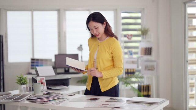 Asian woman adult professional reviewing color palettes design samples office studio workspace planning project development graphic interior architect expert business organizing