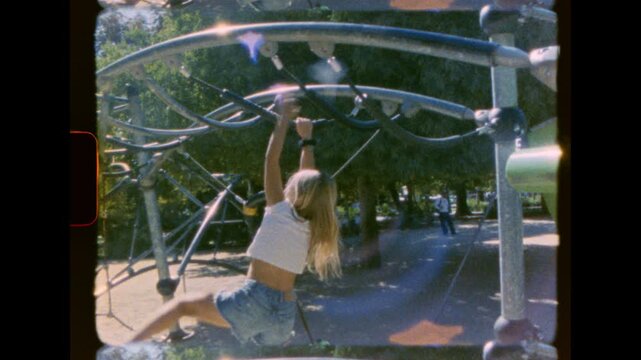 A young girl climbs a complex old metal playground structure in daylight captured on analog super 8 film with frame border