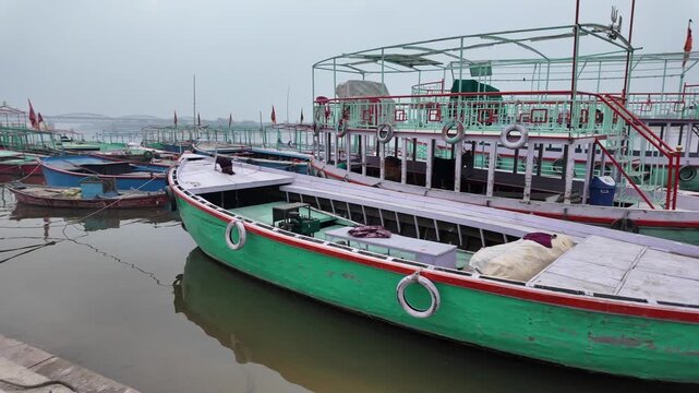 Passenger Boats Moored at River Ghat with Bridge in Background