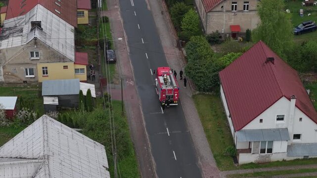 Volunteer firefighters from a rural Polish village celebrating Wet Monday (Śmigus-Dyngus), joyfully splashing water and playing with local residents in a festive spring tradition