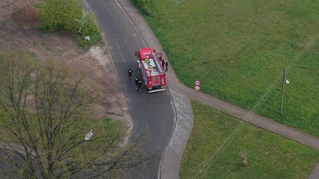 Volunteer firefighters from a rural Polish village celebrating Wet Monday (Śmigus-Dyngus), joyfully splashing water and playing with local residents in a festive spring tradition