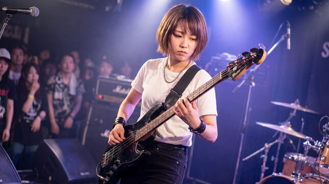 ライブハウスでエレキベースを演奏する日本人女性