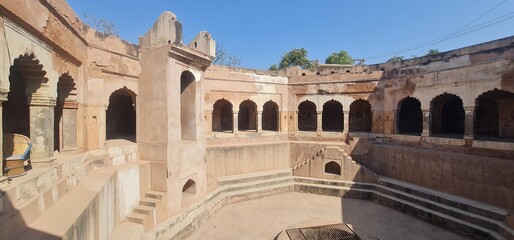 Obraz premium Ancient circular stepwell known as Goal Bavdi featuring medieval period masonry and stone steps in Farukhnagar, Haryana