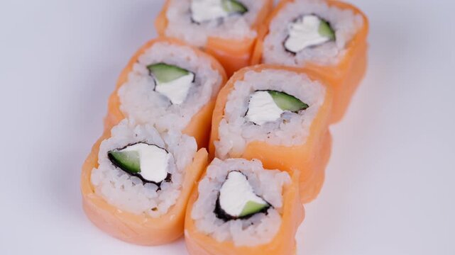 Closeup image of salmon sushi rolls with fresh ingredients. Detailed studio image highlighting salmon wrapped sushi with crisp texture and appealing presentation