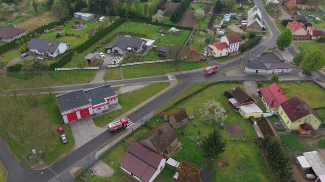 Volunteer firefighters from a rural Polish village celebrating Wet Monday (Śmigus-Dyngus), joyfully splashing water and playing with local residents in a festive spring tradition