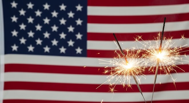 Two bright sparkling sparklers burning in front of a blurred american flag for independence day