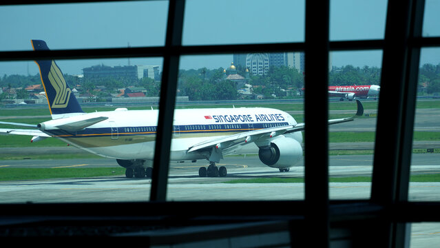View of Singapore Airlines plane taxing on the runway seen through the terminal glass window during daytime on March 20, 2026 in Soekarno-Hatta Interational Airport, Jakarta, Indonesia.