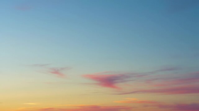Ultra-wide, perfectly static video of a tranquil gradient sky, blending cerulean blue, apricot orange, blush pink, and lemon yellow with diffused wispy clouds. High-key lighting for golden or blue