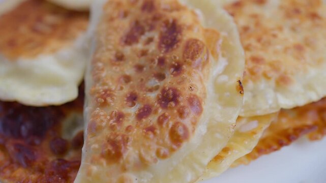 Crispy meat pastries, Golden fried chebureki showcasing rustic homemade appeal, Closeup of fried chebureki revealing bubbly browning and rustic homemade crust textures